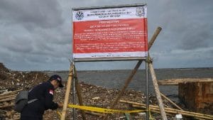 Petugas PPSA LHK Kementerian Lingkungan Hidup dan Kehutanan memasang garis larangan melintas di lokasi proyek pagar laut yang disegel di Pesisir Tarumajaya.